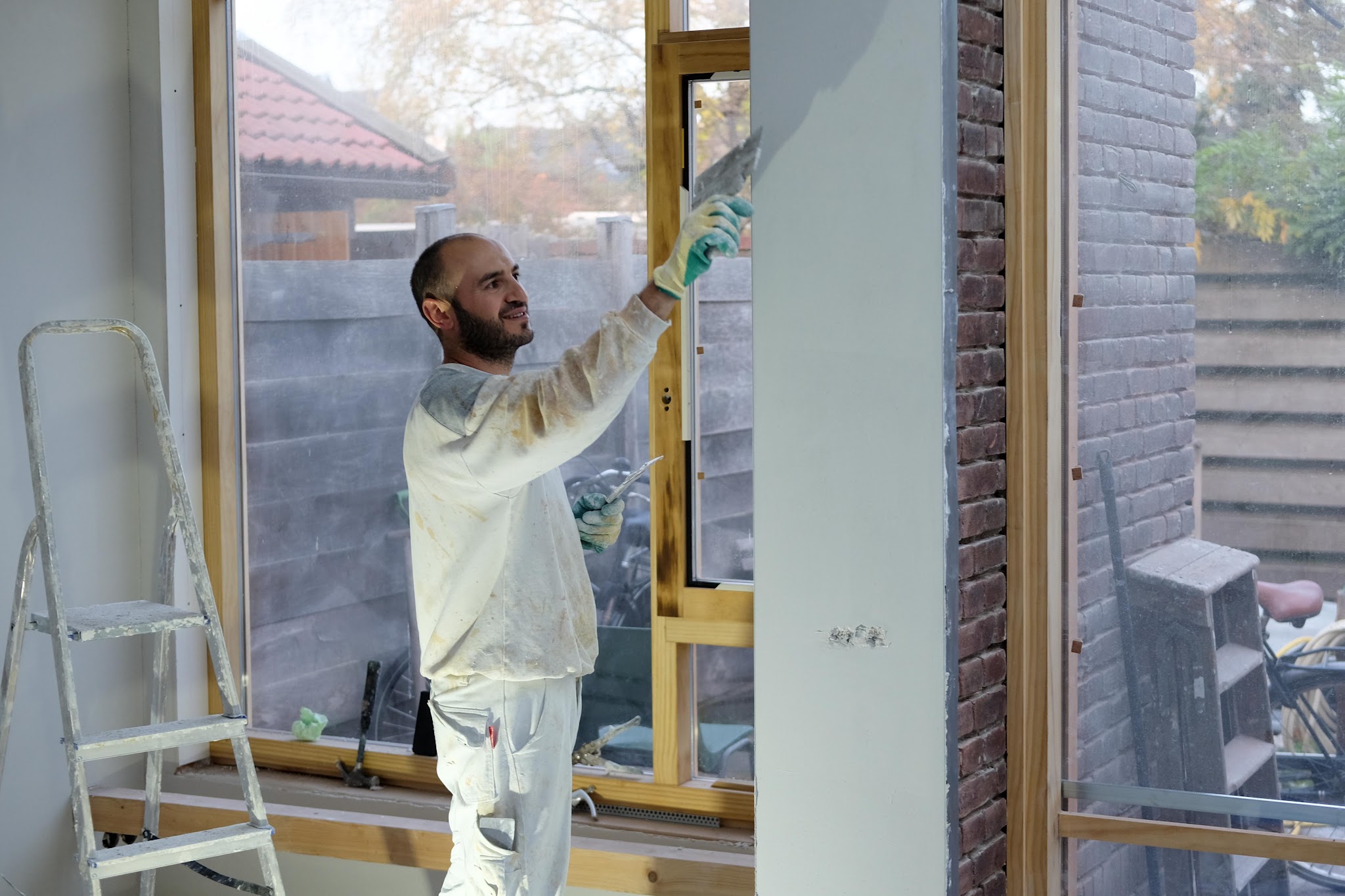 Murat stuct een wand naast het kozijn