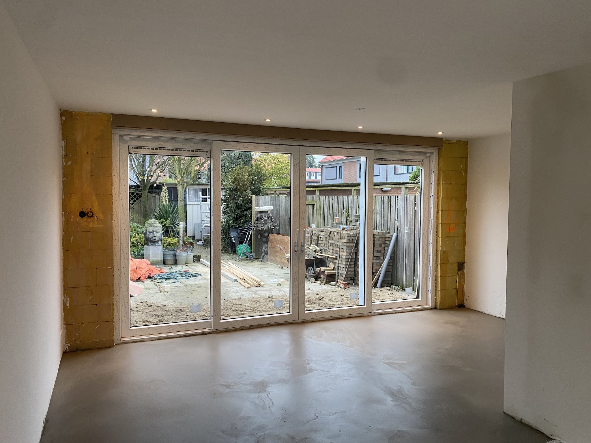Woonkamer richting de tuindeuren, muren in bewerking