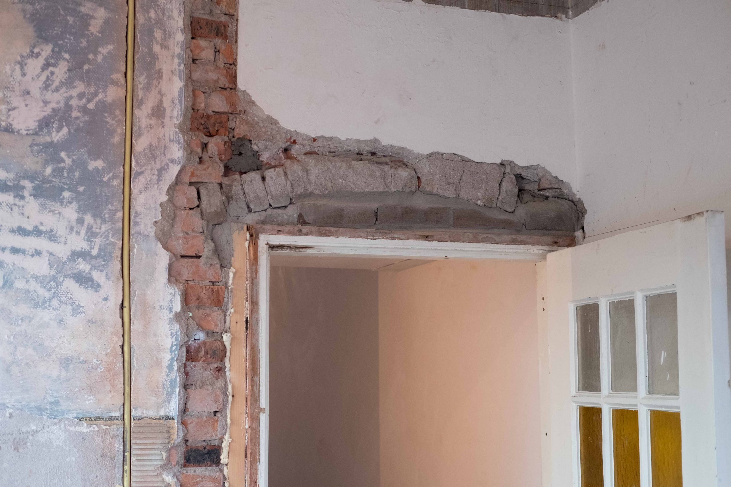 Kale bakstenen muur en deuropening voor het stucwerk